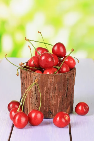 Cherry bessen in pot op houten tafel op lichte achtergrond — Stockfoto