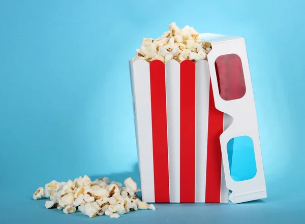 Palomitas de maíz y gafas 3D sobre fondo azul —  Fotos de Stock