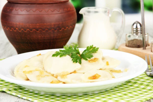 Tasty dumplings with fried onion on white plate, on bright background — Stock Photo, Image