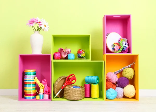 Bunte Regale in verschiedenen Farben mit Utensilien auf Wandhintergrund — Stockfoto