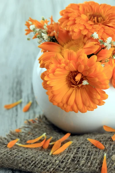 木製の背景上に花瓶にキンセンカの花 — ストック写真