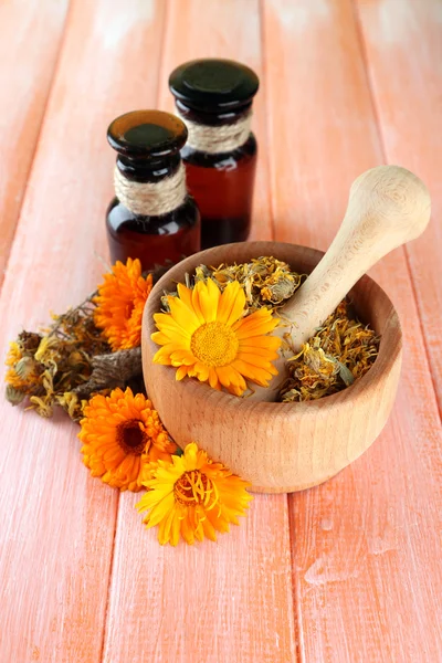 Garrafas de medicina e flores de calêndula em fundo de madeira — Fotografia de Stock