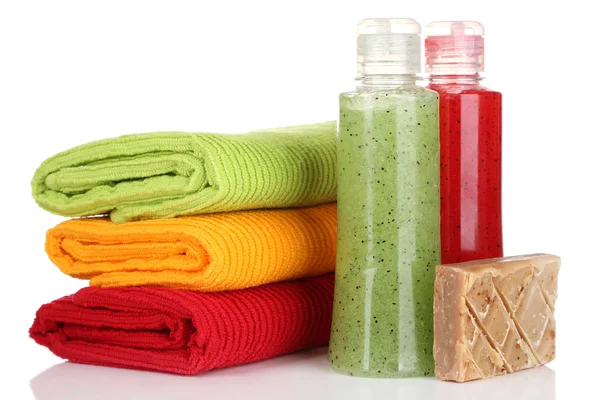 Kleurrijke handdoeken, cosmetica flessen en zeep, geïsoleerd op wit — Stockfoto