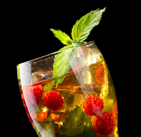 Iced tea with raspberries and mint on black background — Stock Photo, Image