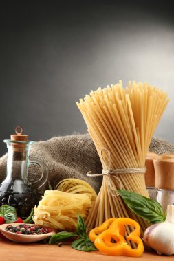 makarna makarna, sebze ve Baharatlar, gri arka plan üzerinde ahşap tablo