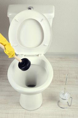 kadın bir klozet banyo unclog için bir dalgıç kullanır