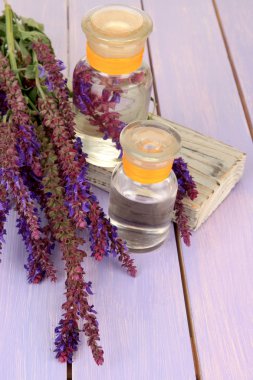 Ada çayı çiçekler mor ahşap zemin ile ilaç şişeleri