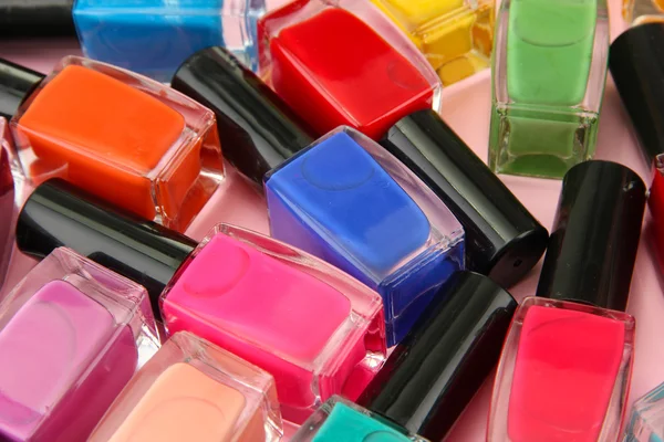 Grupo de esmaltes de uñas brillantes, sobre fondo rosa —  Fotos de Stock
