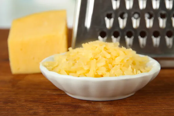 Ralador de metal e queijo, sobre fundo brilhante — Fotografia de Stock