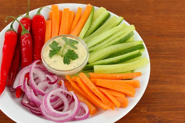 Verduras cruas sortidas varas na chapa na mesa de madeira de perto — Fotografia de Stock