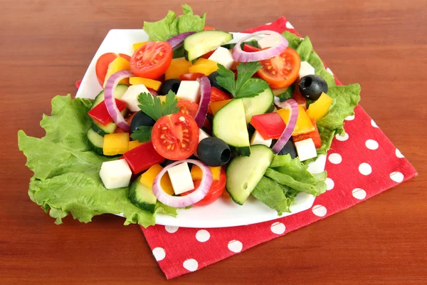 Välsmakande grekisk sallad på trä bakgrund — Stockfoto