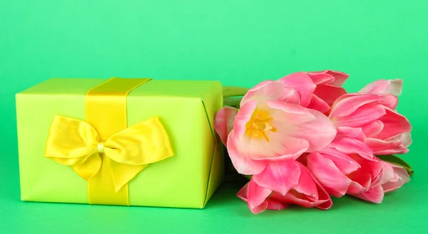 Rózsaszín tulipán és ajándék doboz, színes háttérrel — Stock Fotó