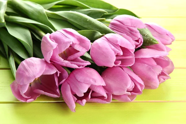 Beau bouquet de tulipes violettes sur fond de bois vert — Photo