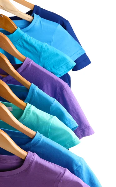 Lots of T-shirts on hangers isolated on white — Stock Photo, Image