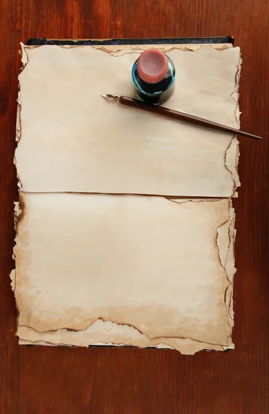 Abra a tinta velha do livro e a pena da tinta no fundo de madeira — Fotografia de Stock
