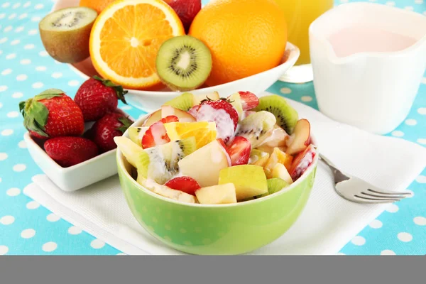 Корисний фруктовий салат зі свіжих фруктів і ягід в мисці на скатертині крупним планом — стокове фото