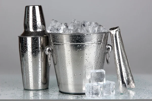 Cubo de hielo de metal y agitador sobre fondo gris —  Fotos de Stock