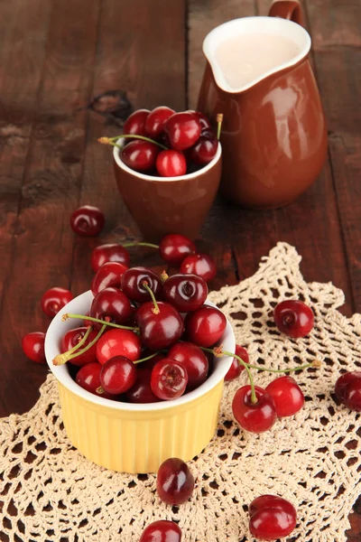 Ripe red cherry berries in bowl on wooden table close-up — Stock Photo, Image