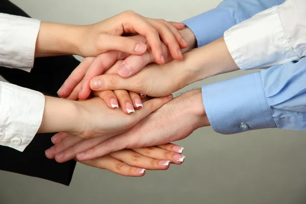 Gruppen av unga människors händer på grå bakgrund — Stockfoto