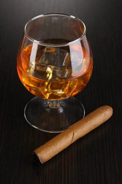 Brandy glas met ijs op houten achtergrond — Stockfoto