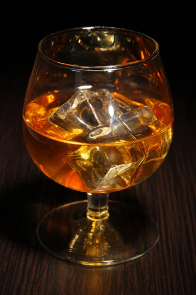 Schnapsglas mit Eis auf Holzgrund — Stockfoto