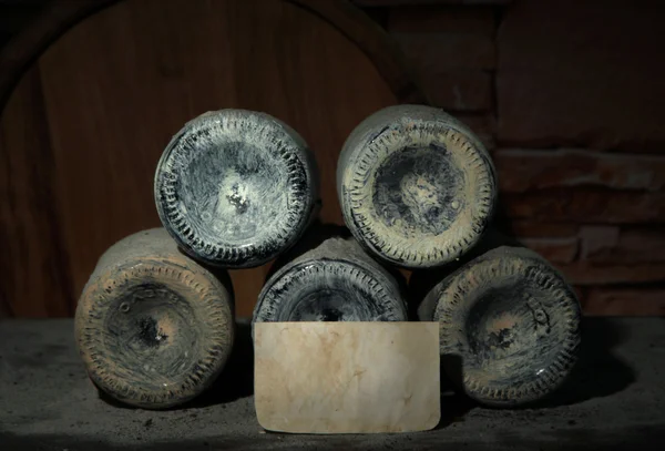 Old bottles of wine in old cellar, on dark background — Stock Photo, Image