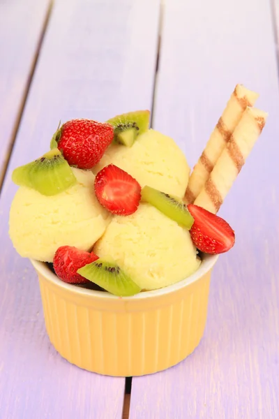 Delicious ice cream with fruits and berries in bowl on wooden table — Stock Photo, Image