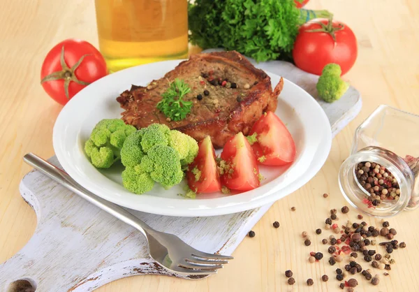 Piece of fried meat on plate on wooden table close-up — Stock Photo, Image