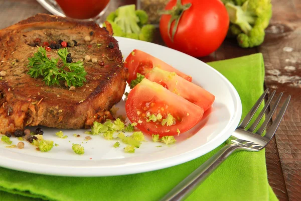 Trozo de carne frita en el plato en la mesa de madera de cerca — Foto de Stock