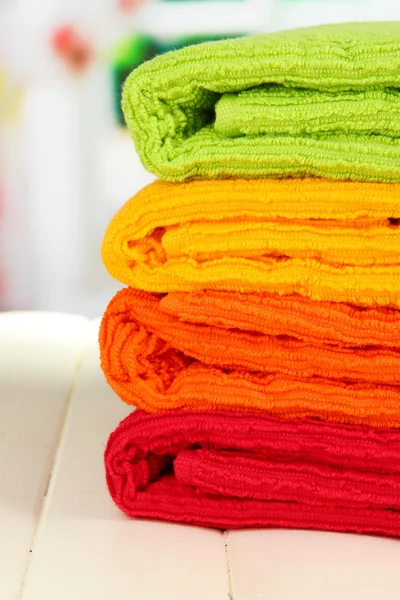 窗口背景上的木桌上的色彩鲜艳毛巾 — 图库照片