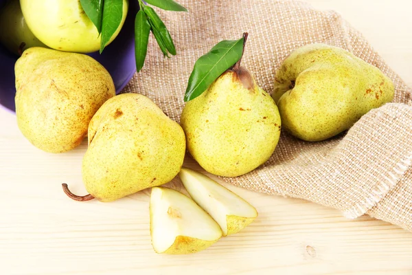 Pears in bucket on burlap on wooden table — Stock Photo, Image