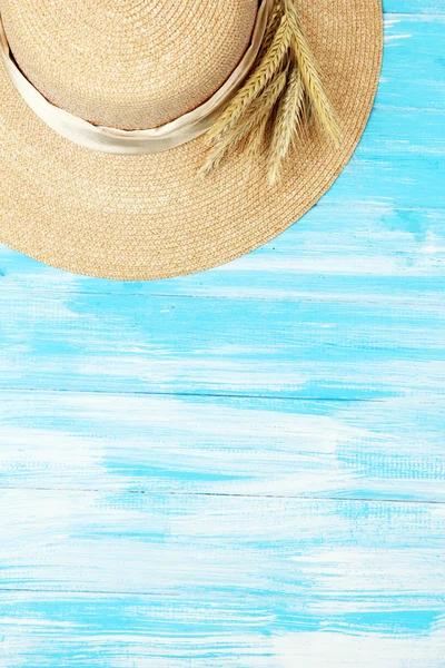 Bonito chapéu de verão com espiguetas em fundo de madeira azul — Fotografia de Stock