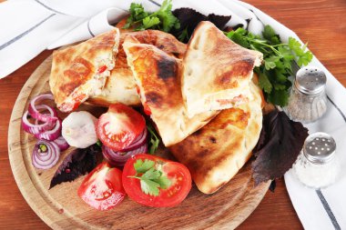 Pizza calzones peçete ahşap masa üzerinde yakın ahşap tahta üzerinde