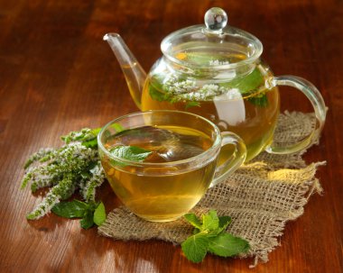 fincan ve ahşap masa çiçekleri taze nane ile bitkisel çay demlik