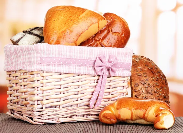 Baked bread in wicker basket on window background — Stock Photo, Image