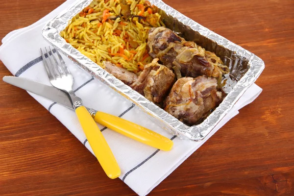 Comida en caja de papel de aluminio sobre servilleta sobre fondo de madera —  Fotos de Stock