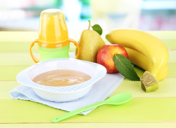 Leckeres Babyfruchtpüree und Babyflasche auf Holztisch — Stockfoto