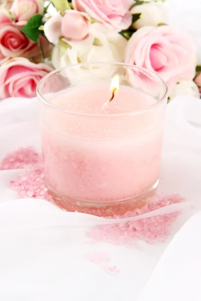 Beautiful candle with flowers on white cloth, close up — Stock Photo, Image