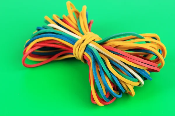 Colorful rubber bands on green background — Stock Photo, Image