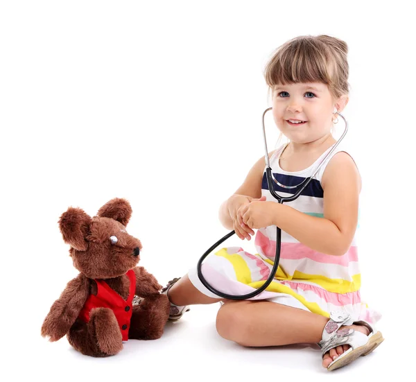 Маленька мила дівчинка грає у лікаря, ізольована на білому — стокове фото