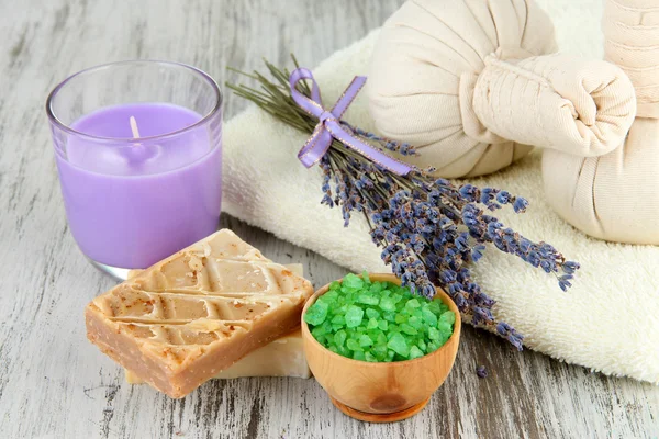 Natureza morta com vela de lavanda, sabão, bolas de massagem, sabão e lavanda fresca, sobre fundo de madeira — Fotografia de Stock