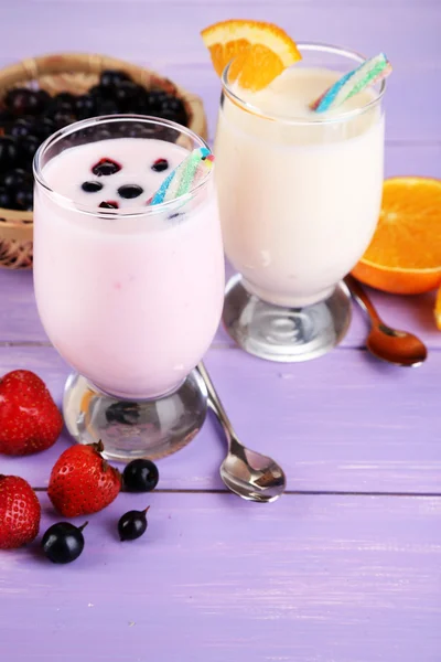 Leckere Milchshakes mit Orange und Brombeere auf Holztisch in Großaufnahme — Stockfoto