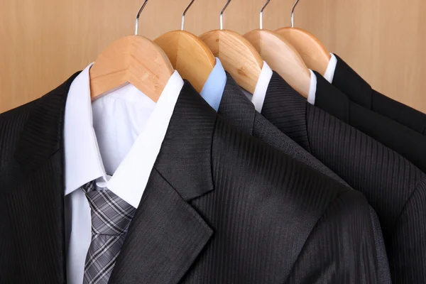 Pakken met shirts op hangers op houten achtergrond — Stockfoto