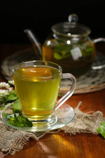 Cup and teapot of herbal tea with fresh mint flowers on wooden table — Stock Photo, Image