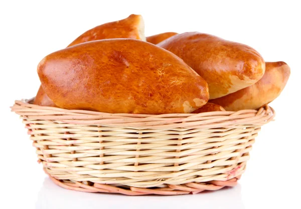 Fresh baked pasties in wicker basket, isolated on white — Stock Photo, Image