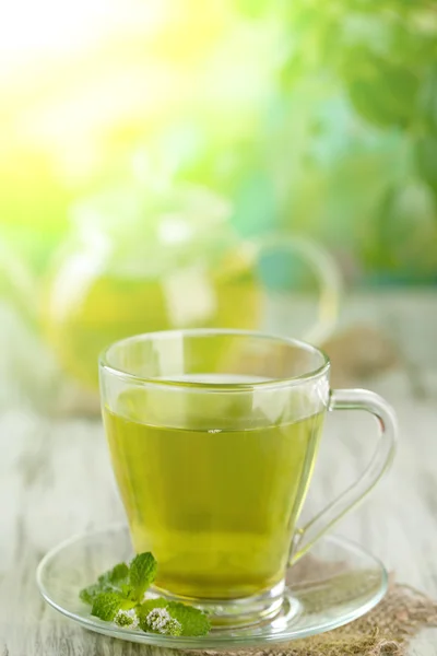 Cup of herbal tea with fresh mint flowers on wooden table — Stock Photo, Image