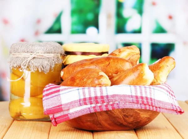 Färska bakat piroger med frukt, sylt, på träbord, på ljus bakgrund — Stockfoto