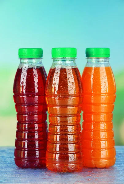 Ассортимент бутылок с вкусными фруктовыми соками на ярком фоне — стоковое фото