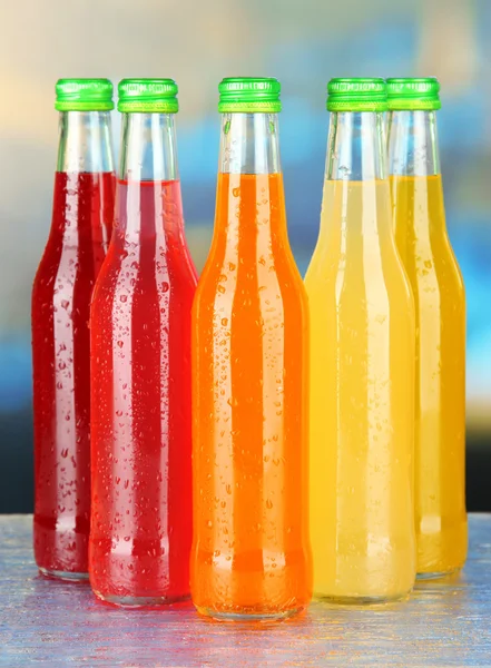 Bottles with tasty drinks on bright background — Stock Photo, Image