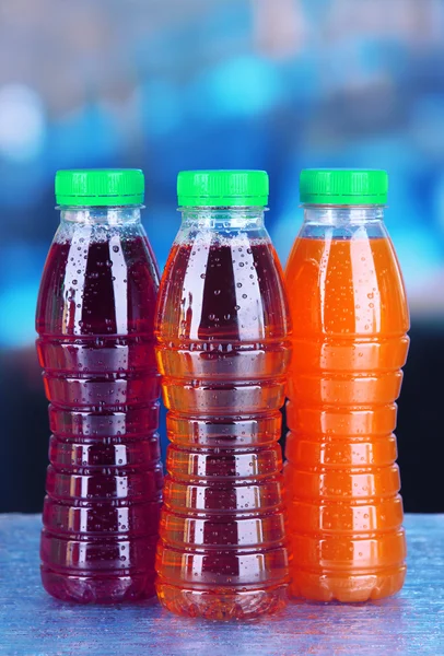 Assortimento di bottiglie con succhi di frutta gustosi su sfondo brillante — Foto Stock